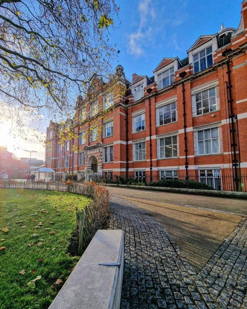 Photograph of the Hawthorn building at De Montfort University, Leicester, UK. It is an old red brick building, four stories high, with a large arched entry.